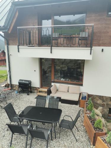 a patio with a table and chairs and a balcony at Villa pod hviezdami Jasná in Demanovska Dolina