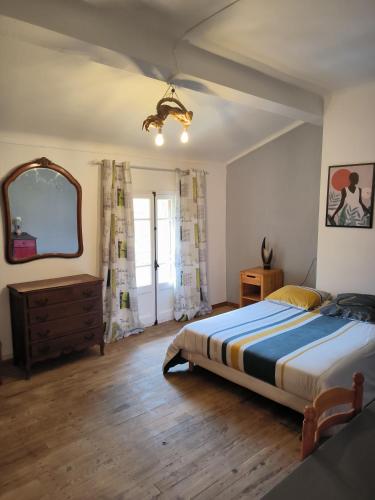 - une chambre avec un lit, un miroir et une commode dans l'établissement Typique maison catalane, à Villelongue-dels-Monts
