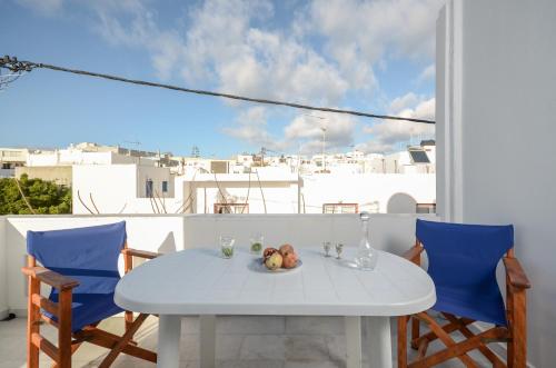 a white table with a bowl of fruit on a balcony at Mike's Studios in Naxos Chora