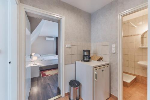 a small bathroom with a refrigerator and a sink at Tokajer Wellness Panzió in Keszthely