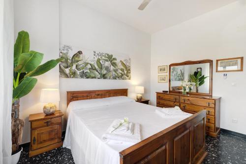 a bedroom with a bed with white sheets and a mirror at Riva Mare 1 in Vado Ligure