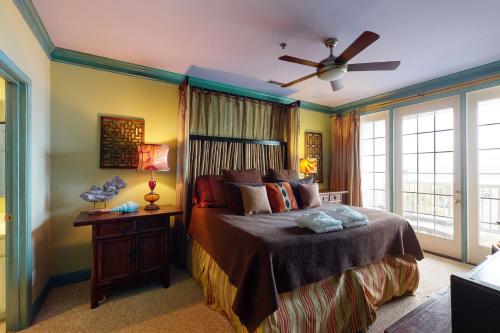 um quarto com uma cama e uma ventoinha de tecto em Pavilion Watch #2E em Folly Beach
