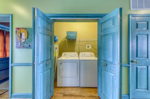 uma lavandaria com portas azuis e uma máquina de lavar e secar roupa em Pavilion Watch #2E em Folly Beach