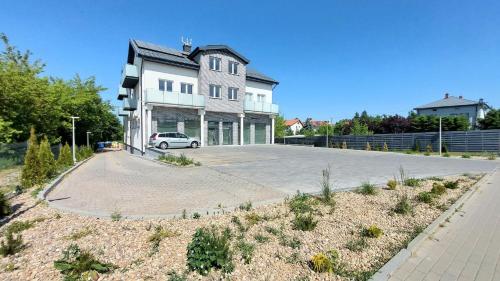 a large house with a car parked in the driveway at Apartament Mariacka in Mława