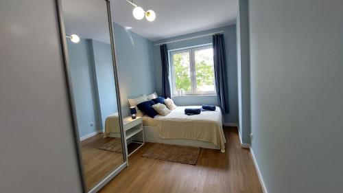 a mirror in a room with a bed and a window at Apartament Mariacka in Mława