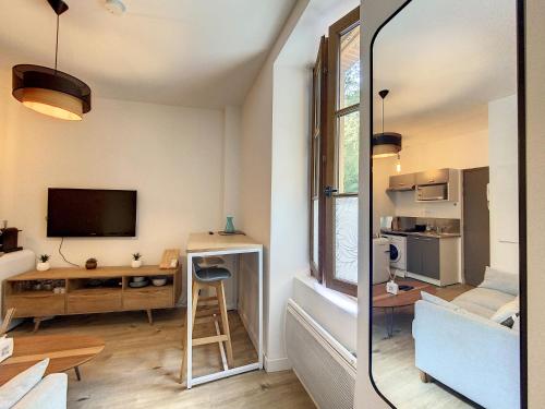 - un salon avec une télévision et un bureau avec un tabouret dans l'établissement ღ Le Cosy Brienne • T2 au Centre-Ville ღ Métro, à Toulouse