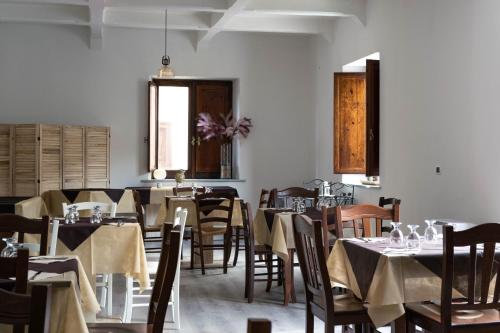 a dining room with tables and chairs and a window at Il Paese Alberga! in Caulonia