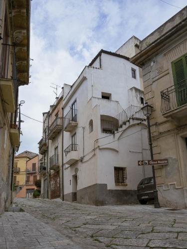 a white building with balconies on a street at Il Paese Alberga! in Caulonia