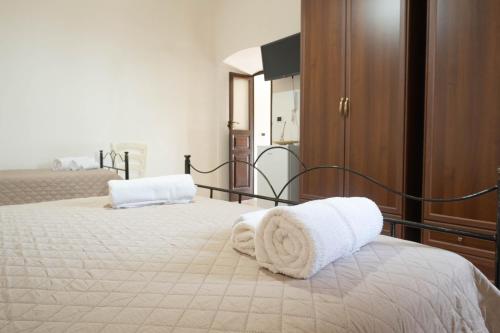 a bedroom with a bed with towels on it at Il Paese Alberga! in Caulonia