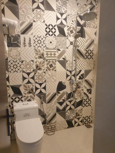 a bathroom with a toilet and a black and white wall at LaLa Apartment and Hotel in Danang