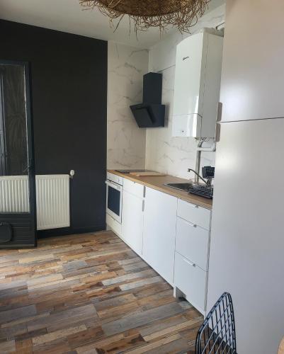 a kitchen with white cabinets and a wooden floor at Marina 4 ou 8 ou 9 in Narbonne