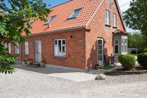a red brick house with a red roof at Nordgården Pension in Onsbjerg