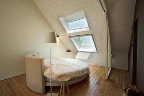 um quarto com uma cama e uma janela em Battre d'eau, verborgen b&b aan het water em Diksmuide