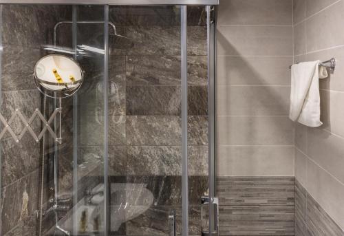una doccia con porta in vetro in bagno di Vemara City Apart Hotel a Varna