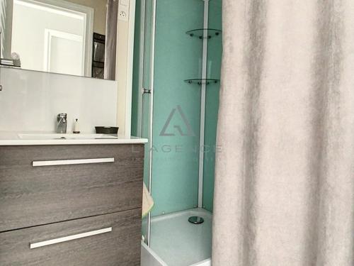 a bathroom with a shower curtain and a sink at Studio Cucq-Stella Plage, 1 pièce, 2 personnes - FR-1-236-84 in Stella-Plage