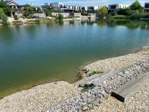 a body of water with buildings in the background at Slnečný dom pri jazere in Hrubá Borša