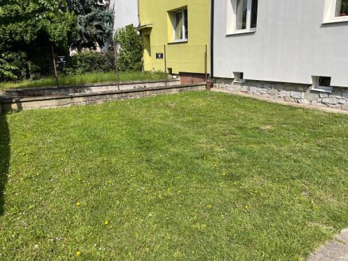 a yard with a green lawn in front of a house at Apartmány Polská 12 in Olomouc