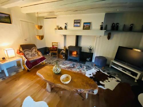 a living room with a coffee table and a fireplace at Maison au pied du pic du Midi in Campan