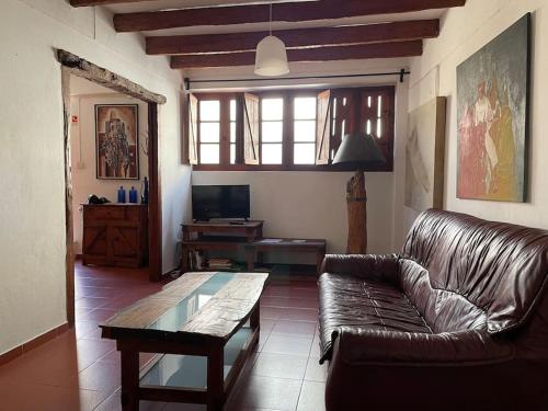 a living room with a leather couch and a table at Casa da Portela in Penacova