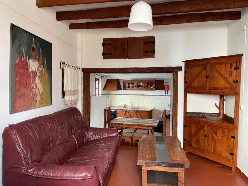 a living room with a leather couch and a table at Casa da Portela in Penacova