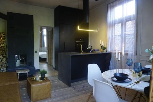 a kitchen and living room with a table and a sink at Modiste in Kuldīga