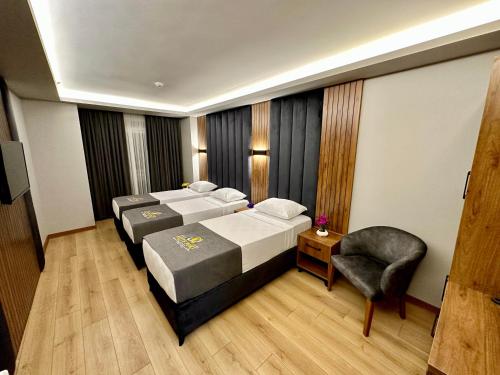 um quarto de hotel com duas camas e uma cadeira em Elite Port Hotel em Arnavutköy