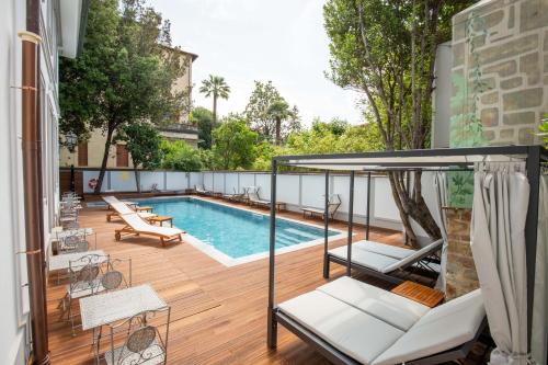 a backyard with a swimming pool and a deck with a swing at Villa Tortorelli in Florence