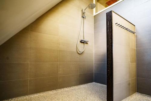 een badkamer met een douche op de zolder bij Loft in romantische stolpboerderij bij duingebied. in Warmenhuizen