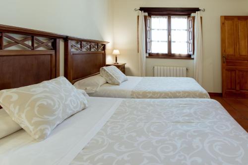 a bedroom with two beds and a window at El Molino de Bonaco in San Vicente de la Barquera