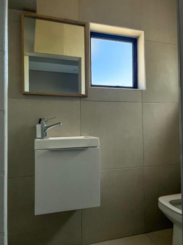 a bathroom with a sink and a window at 6 on Western Guest House in East London