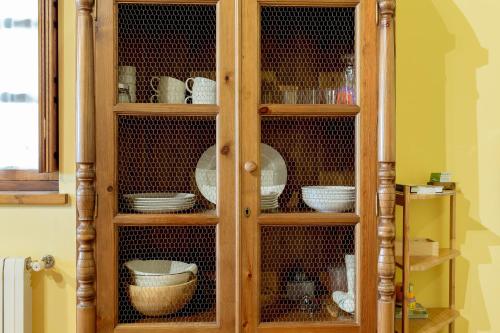 a wooden cabinet with plates and dishes in it at El Molino de Bonaco in San Vicente de la Barquera