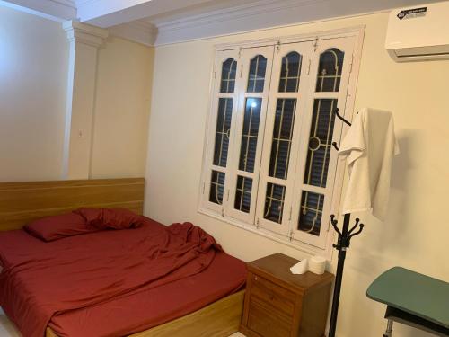 - une chambre avec un lit rouge et une fenêtre dans l'établissement Bong House 5, à Hanoï