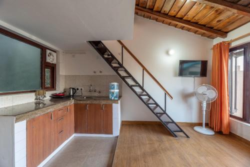 uma cozinha com uma escada em espiral num quarto em Belle Vue, Studio overlooking the hills w wifi by Roamhome em Mukteshwar