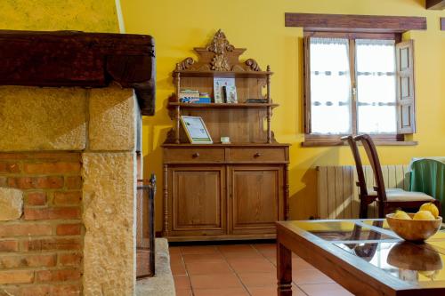 a room with a wooden cabinet and a table and a window at El Molino de Bonaco in San Vicente de la Barquera