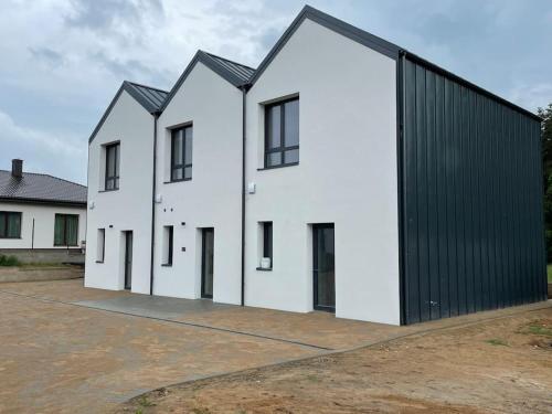 a row of white houses with a black garage at Brand new terraced house. in Mažeikiai