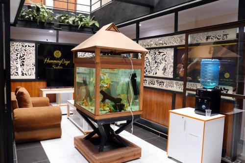a large aquarium in a room with a couch and a chair at Humming Cage Suites studios in Nairobi