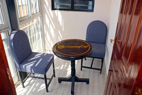 two chairs and a table in a room at Humming Cage Suites studios in Nairobi
