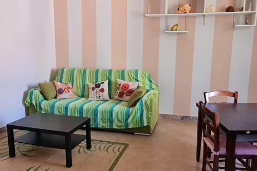 Casetta al centro في توسكانيا: غرفة معيشة مع أريكة خضراء وطاولة