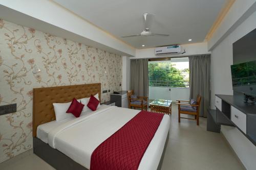 ein Hotelzimmer mit einem Bett und einem TV in der Unterkunft Venice Iva Residency in Alappuzha