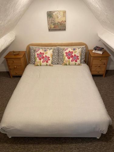 a bedroom with a large bed with two night stands at The Parlour-Farm Stay-IndoorPool-Play Areas-Parkland-Woodland-Lake-Ponds-min 2 nights in Lechlade