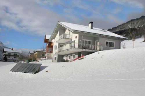 a house sitting on top of a snow covered hill at Ferienwohnung Julia in Bartholomäberg