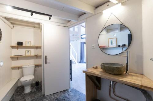 ein Bad mit einem Waschbecken und einem Spiegel in der Unterkunft Studio By KAZUBUNTU in Saint-Leu