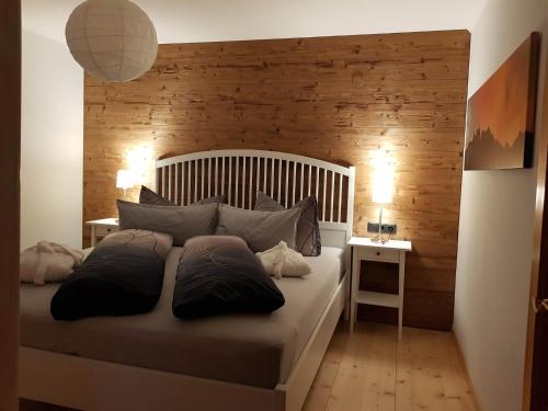 a bedroom with a large bed with a wooden wall at Panorama Chalet Montafon in Bartholomäberg