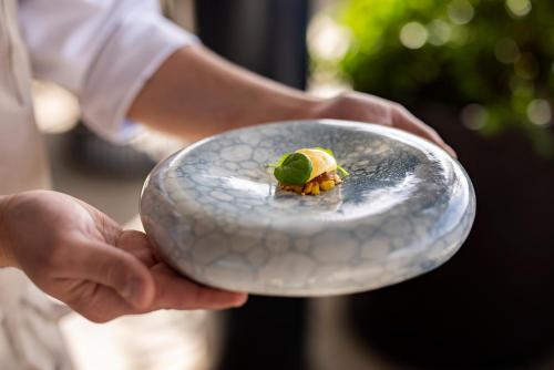 a person holding a plate with a food on it at Grand Park Hotel Rovinj by Maistra Collection in Rovinj
