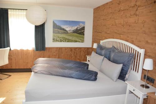 a bedroom with a white bed with blue pillows at Panorama Chalet Montafon in Bartholomäberg
