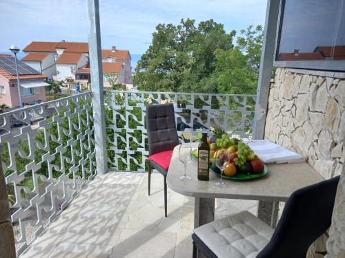 a table with a bowl of fruit on a balcony at D,apartman' ulica pušća 51, 51513 Omišalj in Omišalj
