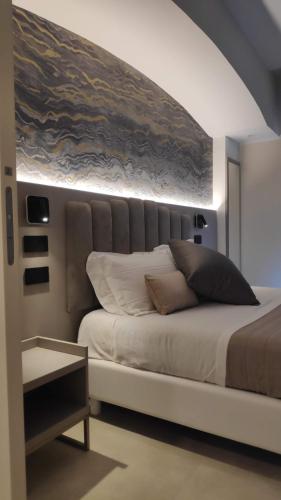 a bedroom with a large bed with a painting on the wall at Hotel Ascot Riccione in Riccione