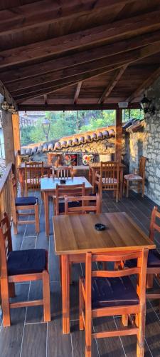 a restaurant with wooden tables and wooden chairs at Bujtina Bega in Berat