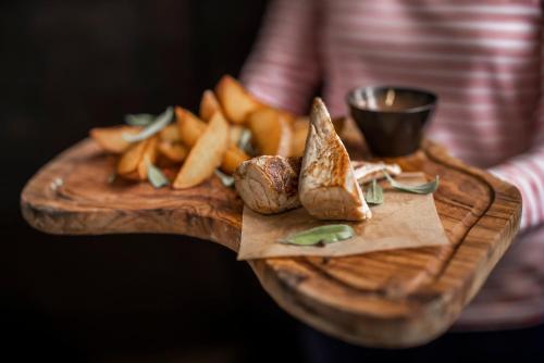 a person holding a wooden cutting board with french fries at Adriatic Hotel by Maistra Collection in Rovinj