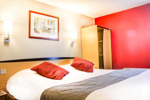 una habitación de hotel con una cama grande con paredes rojas en Hôtel Inn Design Resto Novo Bourges, en Bourges